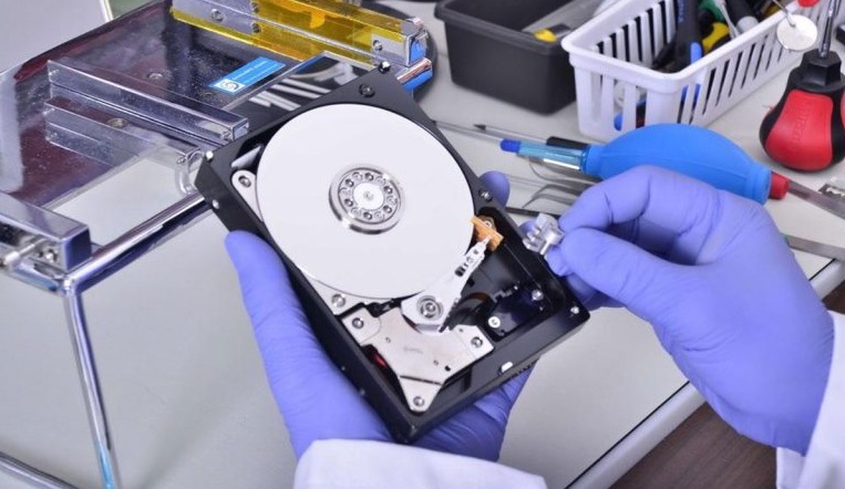 تکنسین در حال بررسی برد آسیب‌دیده هارد پس از شوک الکتریکی